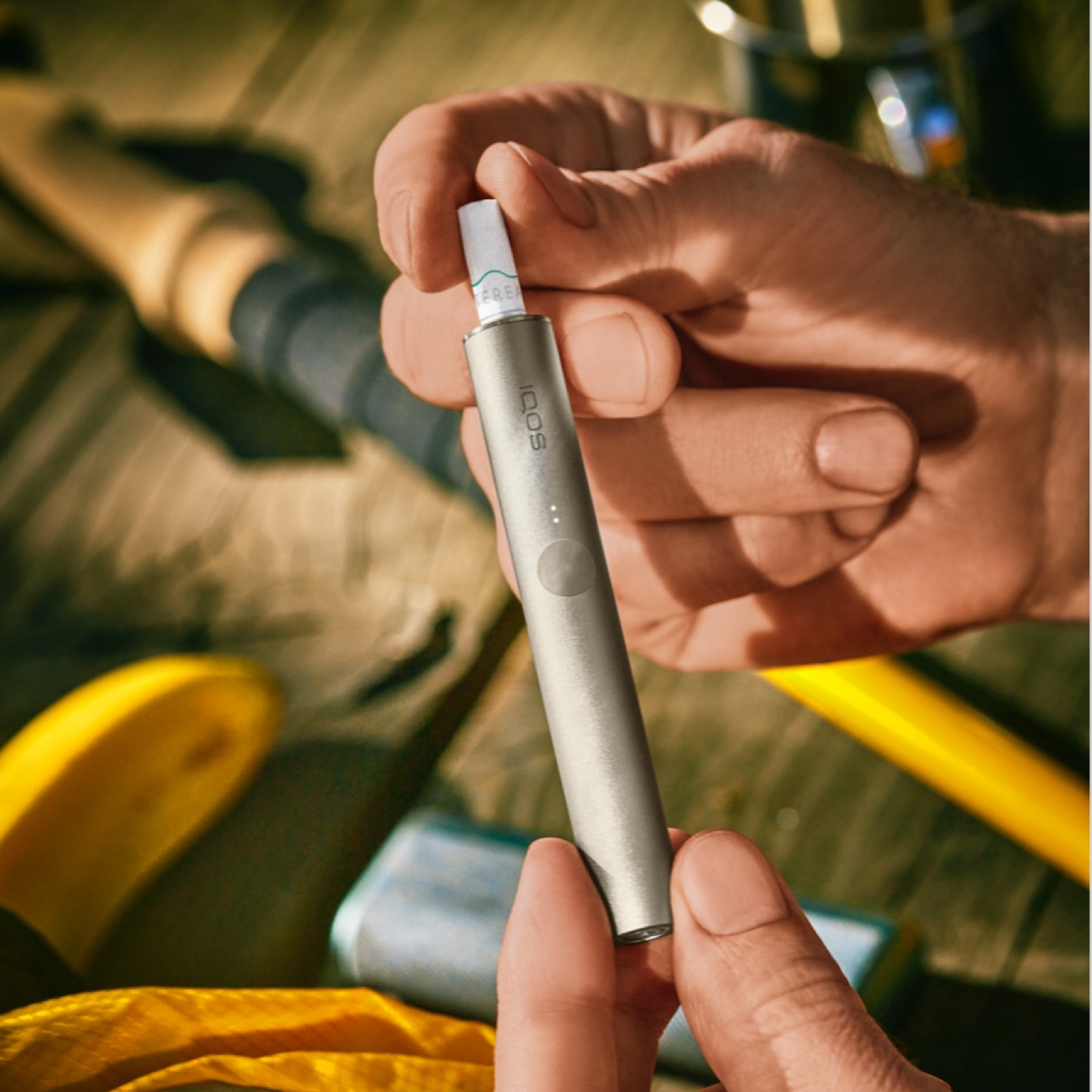 An IQOS ILUMA device in a person's hand.