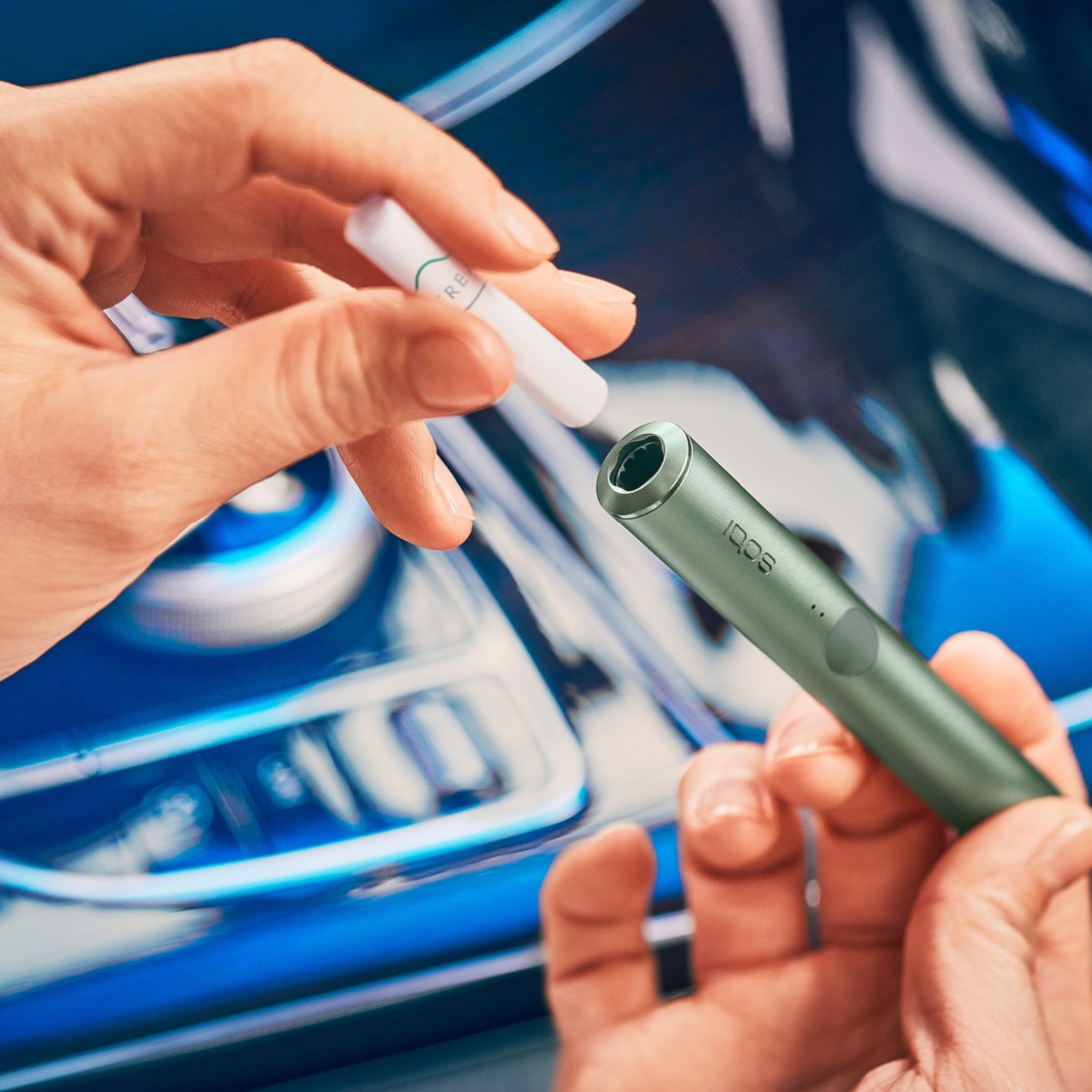 An IQOS ILUMA device in a person's hand.