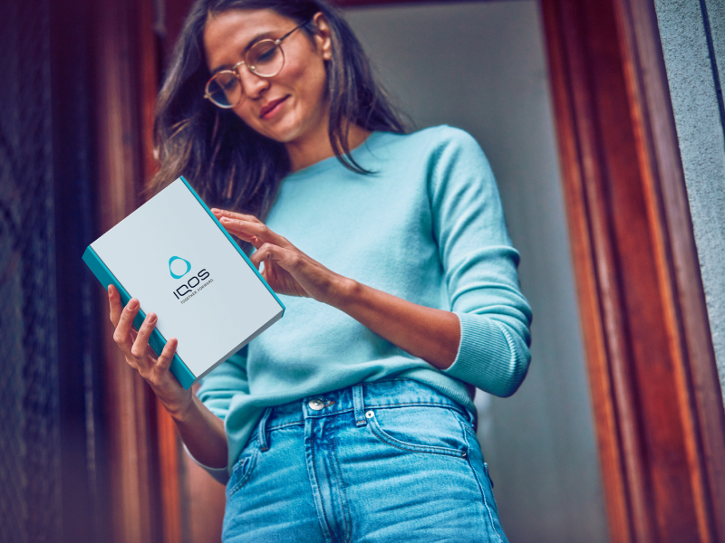Woman opening an IQOS box delivered to her home