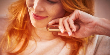 Blond girl with her gold IQOS kit in her hands